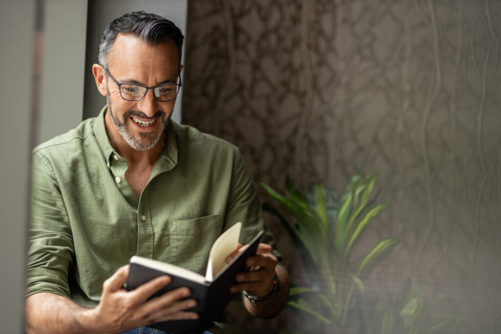 Homem a consultar um caderno ao pesquisar formação gratuita