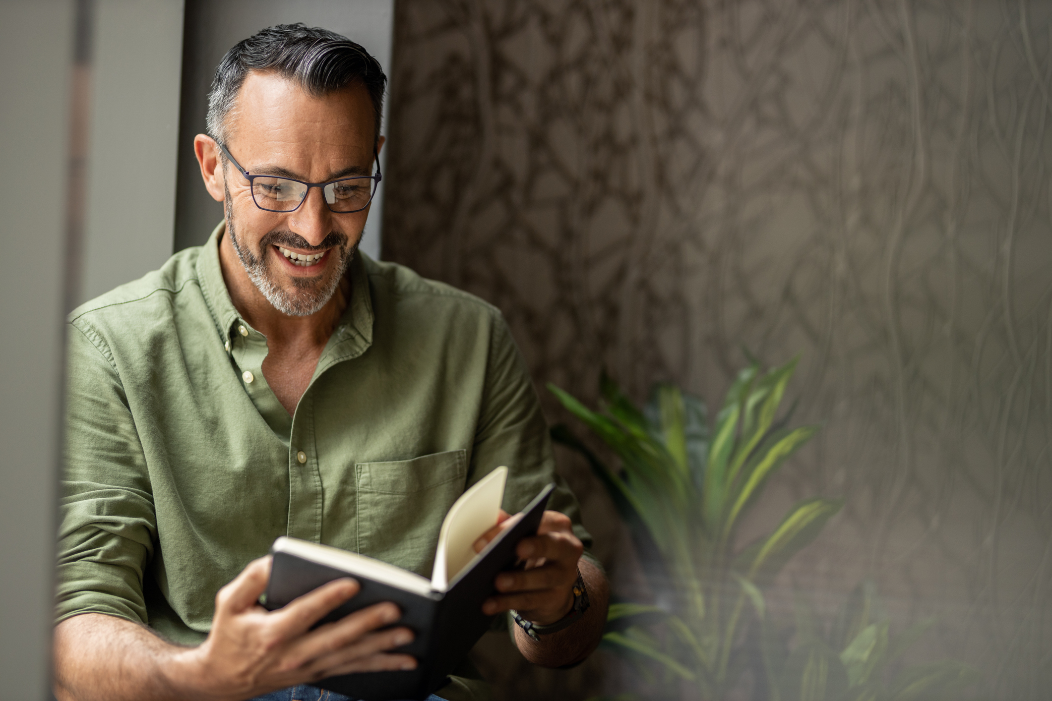 Homem a consultar um caderno ao pesquisar formação gratuita
