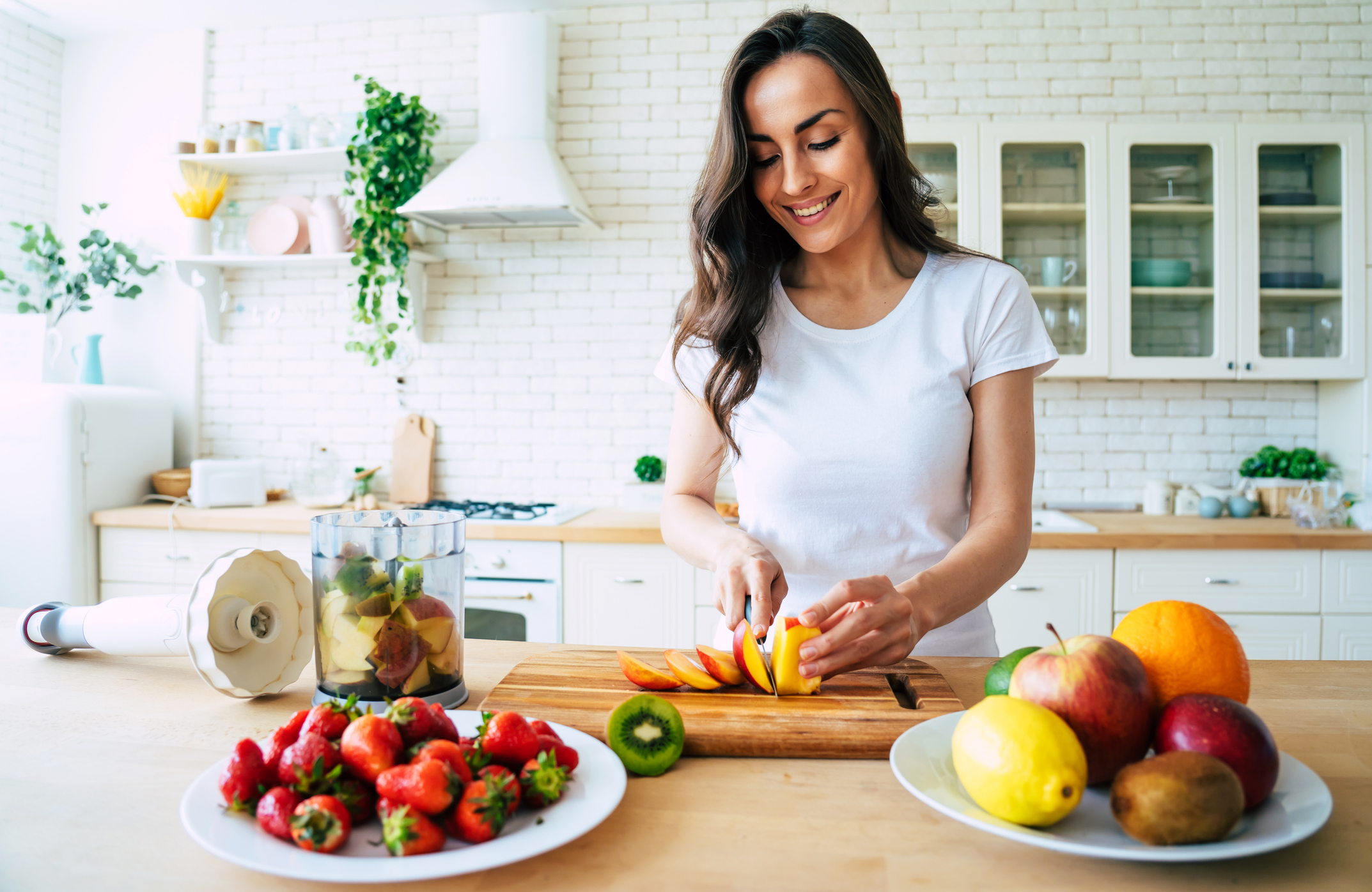 Mulher a preparar fruta fresca numa cozinha moderna